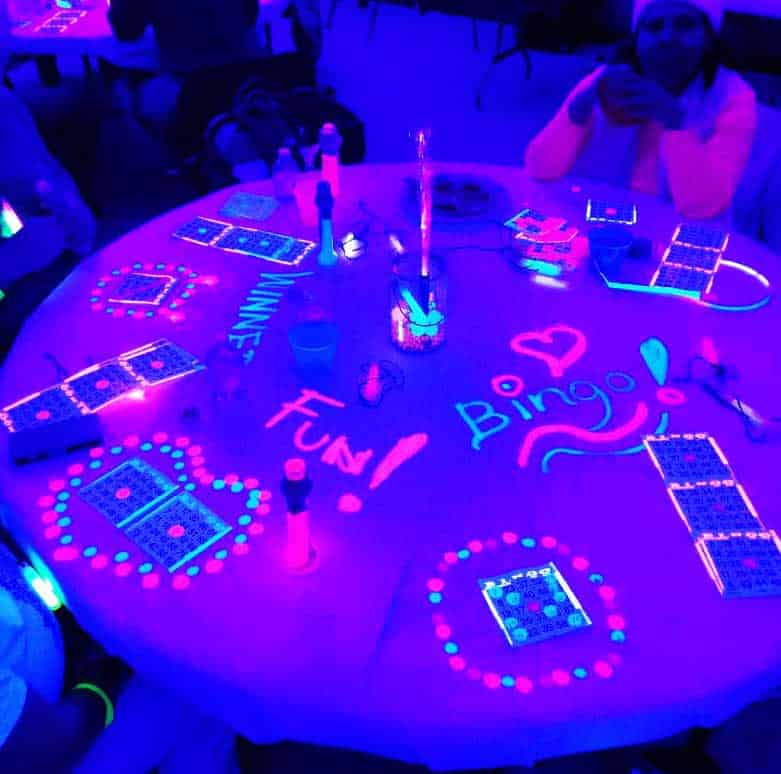 Guests playing Cosmic Bingo with neon lights and music at a corporate or social event in Dallas–Fort Worth