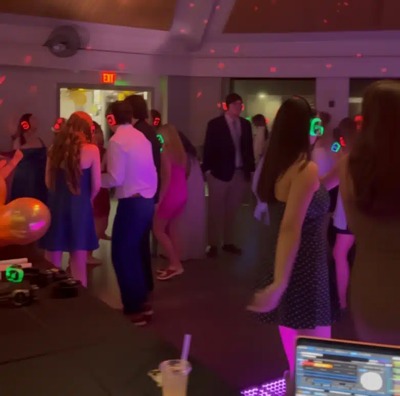 Professional DJ and MC engaging guests at a corporate or wedding event with high-energy music and professional hosting